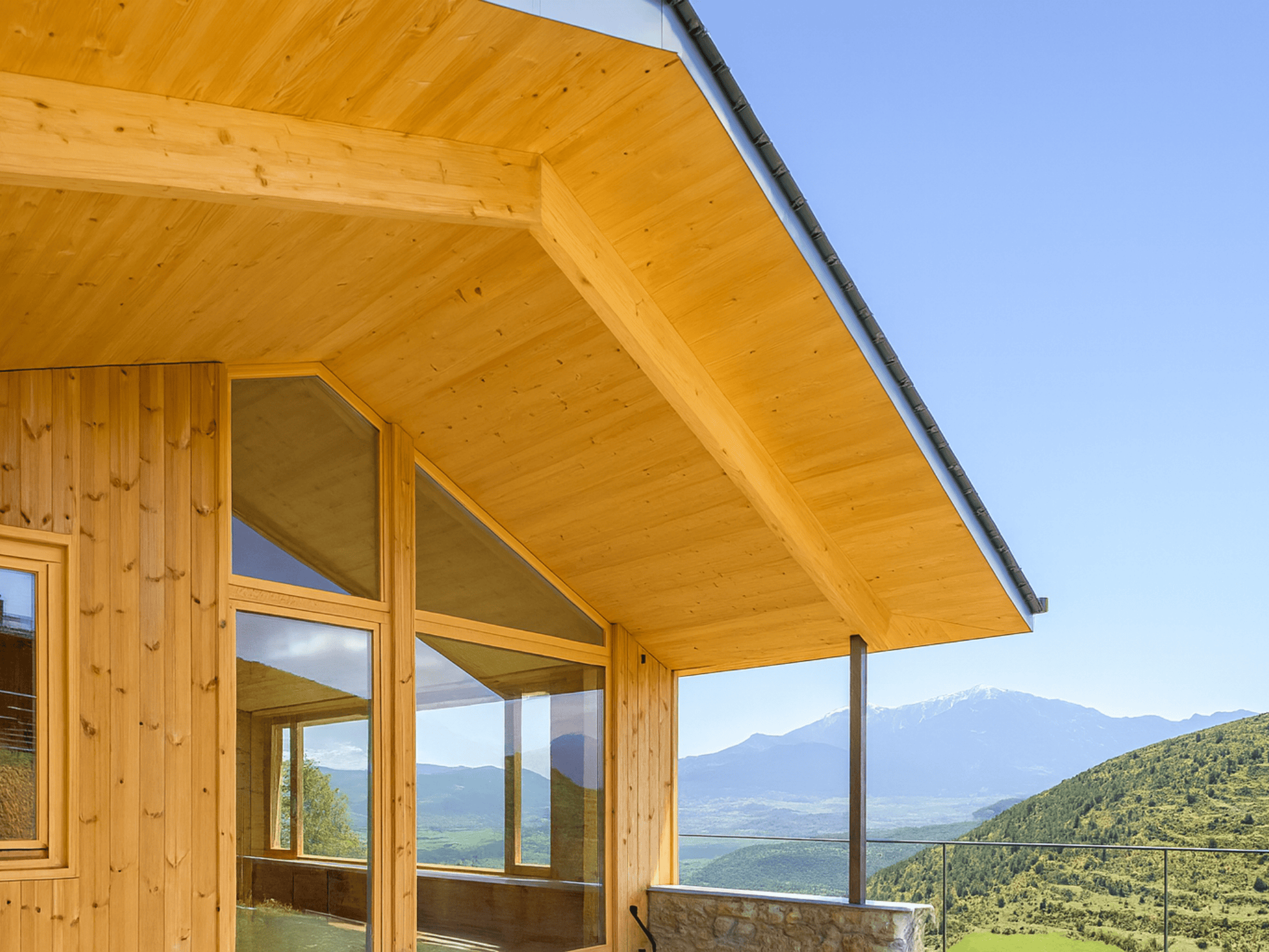 Casa sostenible de madera en Cortàs, La Cerdanya, con vistas al valle, grandes ventanales, orientación sur y diseño pasivo eficiente energéticamente.