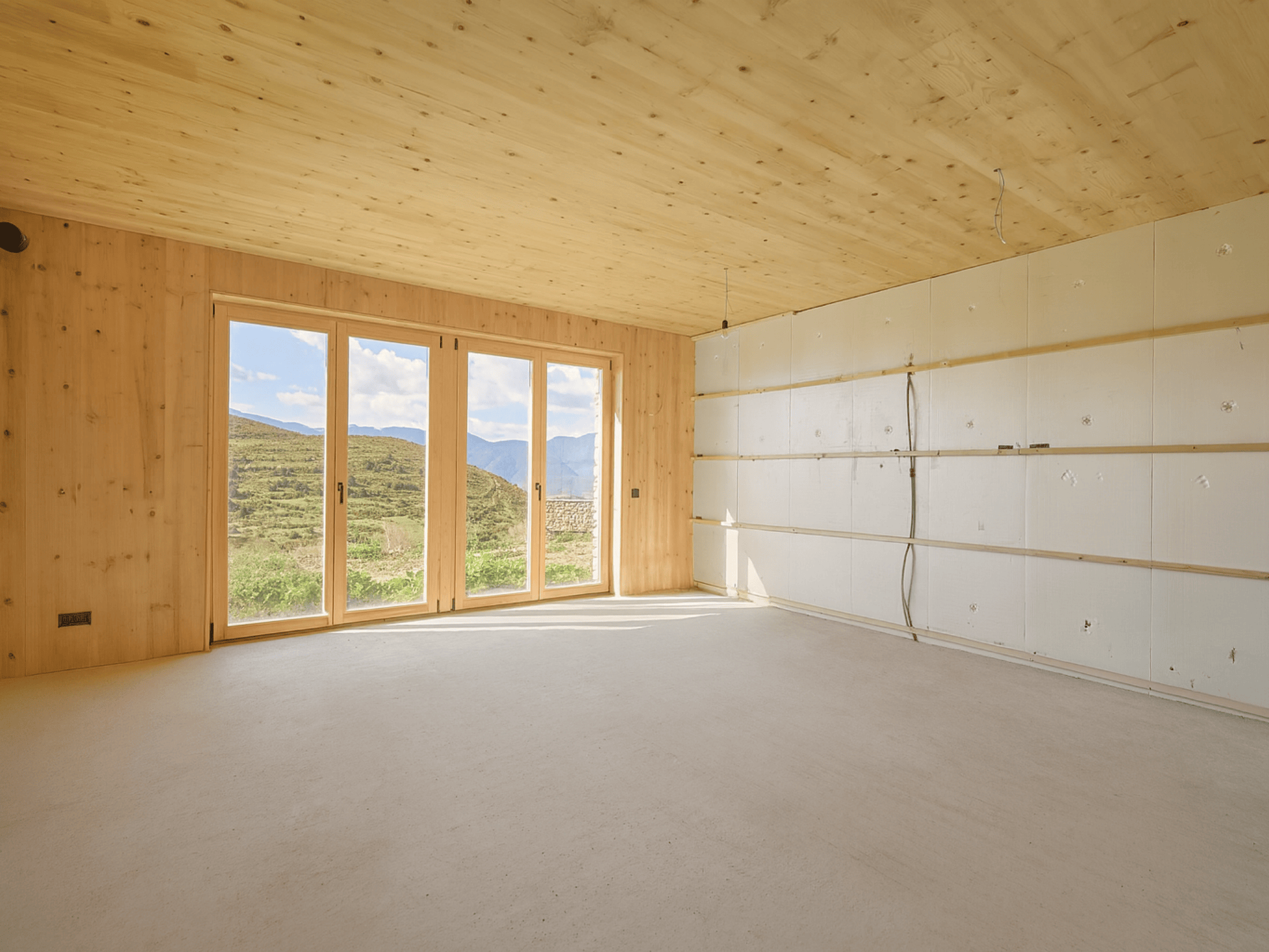 Casa sostenible de madera en Cortàs, La Cerdanya, con vistas al valle, grandes ventanales, orientación sur y diseño pasivo eficiente energéticamente.