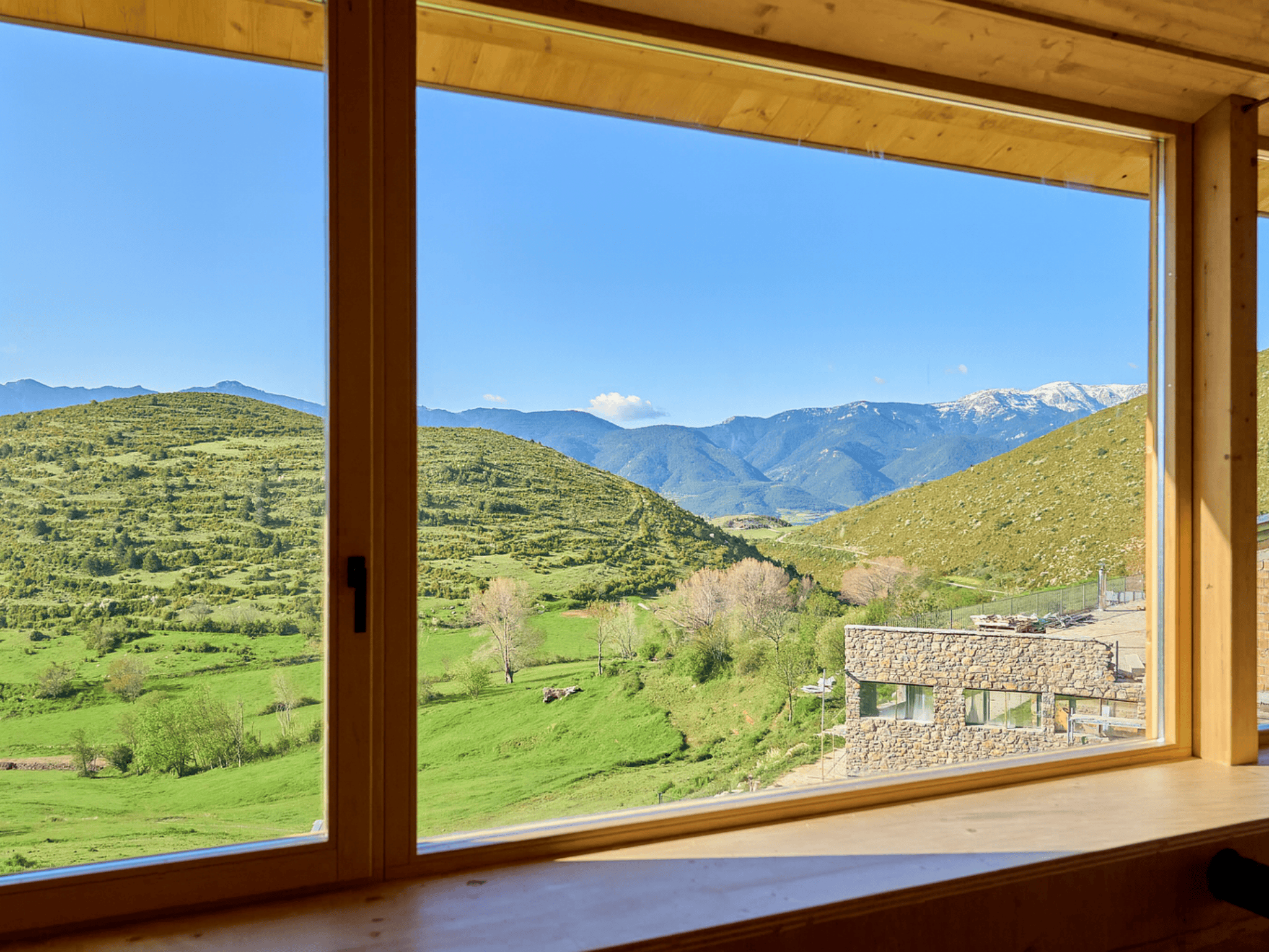 Casa sostenible de madera en Cortàs, La Cerdanya, con vistas al valle, grandes ventanales, orientación sur y diseño pasivo eficiente energéticamente.