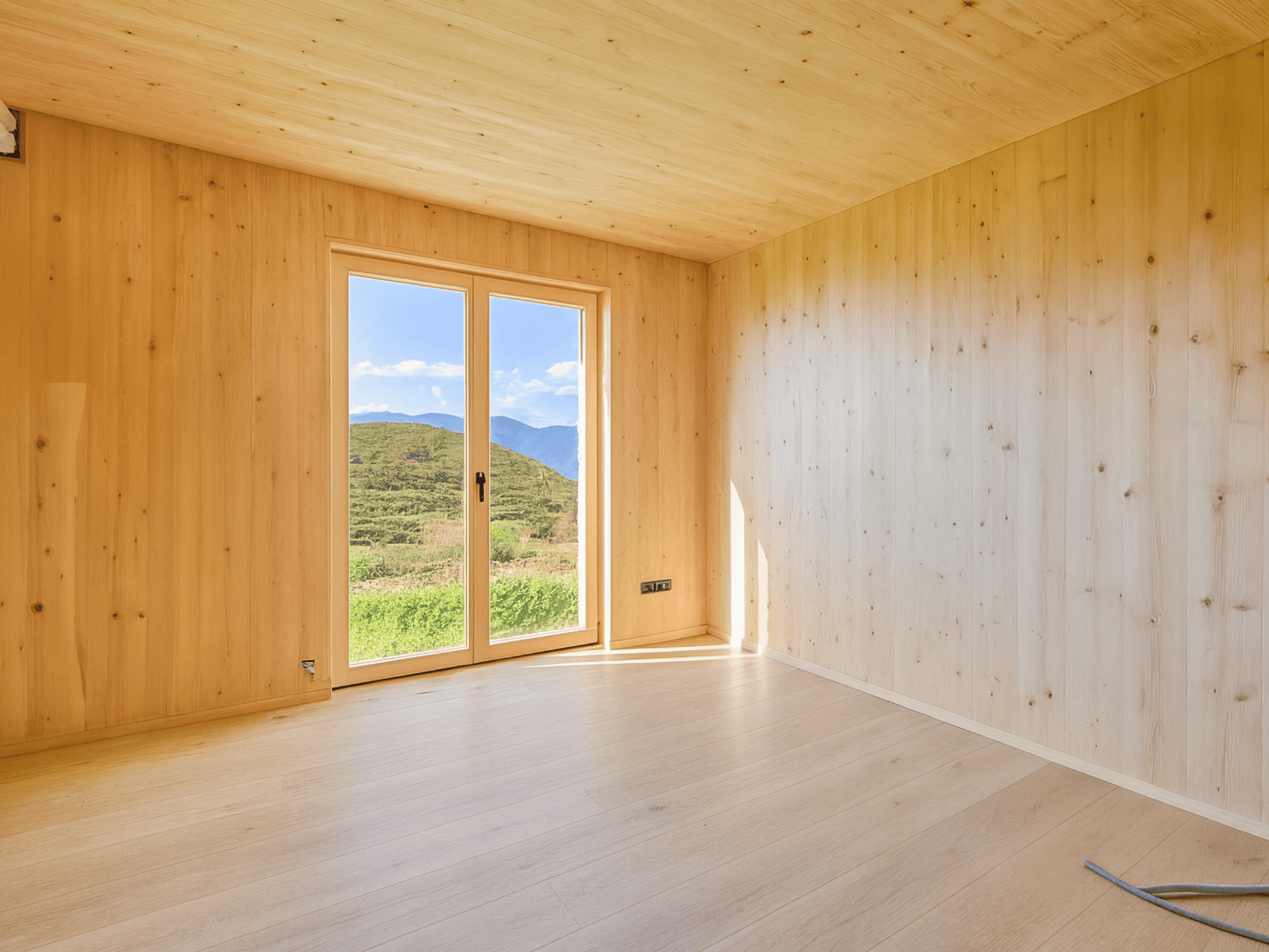 Casa sostenible de madera en Cortàs, La Cerdanya, con vistas al valle, grandes ventanales, orientación sur y diseño pasivo eficiente energéticamente.