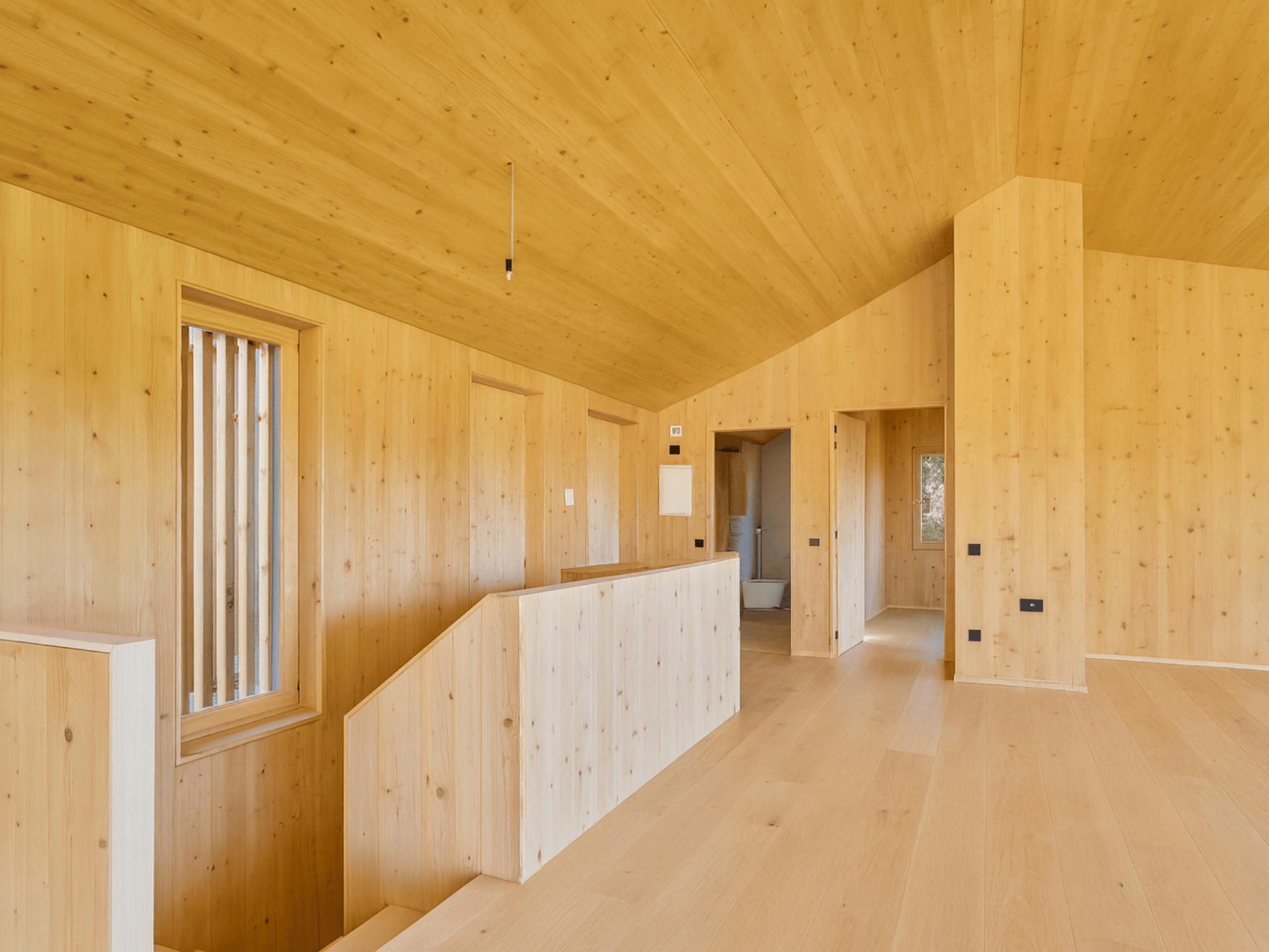 Casa sostenible de madera en Cortàs, La Cerdanya, con vistas al valle, grandes ventanales, orientación sur y diseño pasivo eficiente energéticamente.