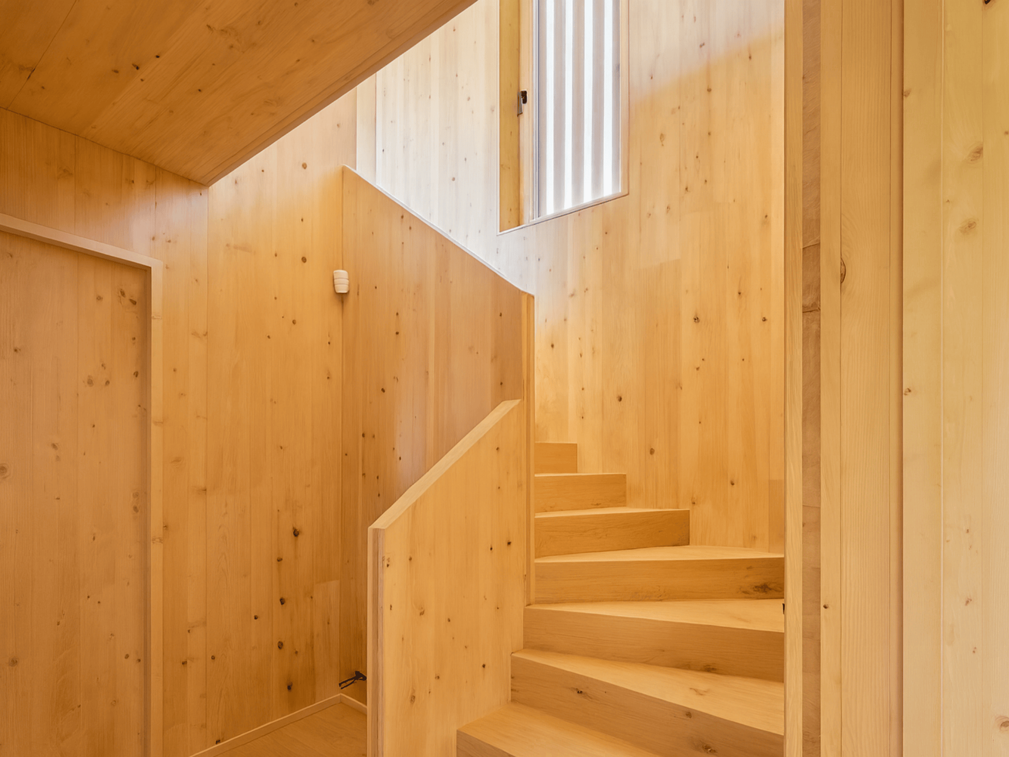 Casa sostenible de madera en Cortàs, La Cerdanya, con vistas al valle, grandes ventanales, orientación sur y diseño pasivo eficiente energéticamente.