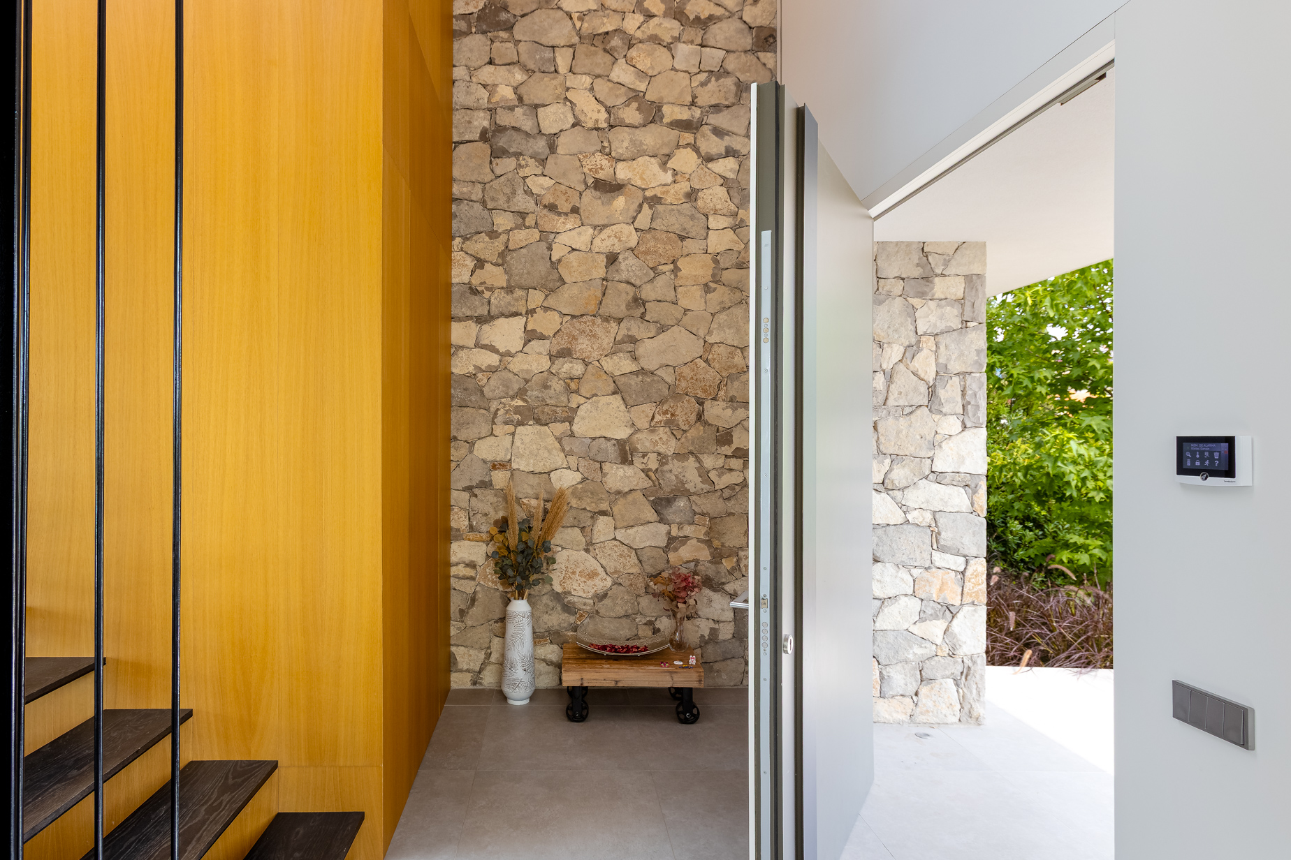 entrada arquitectónica moderna con garaje y piedra natural en villa del Maresme