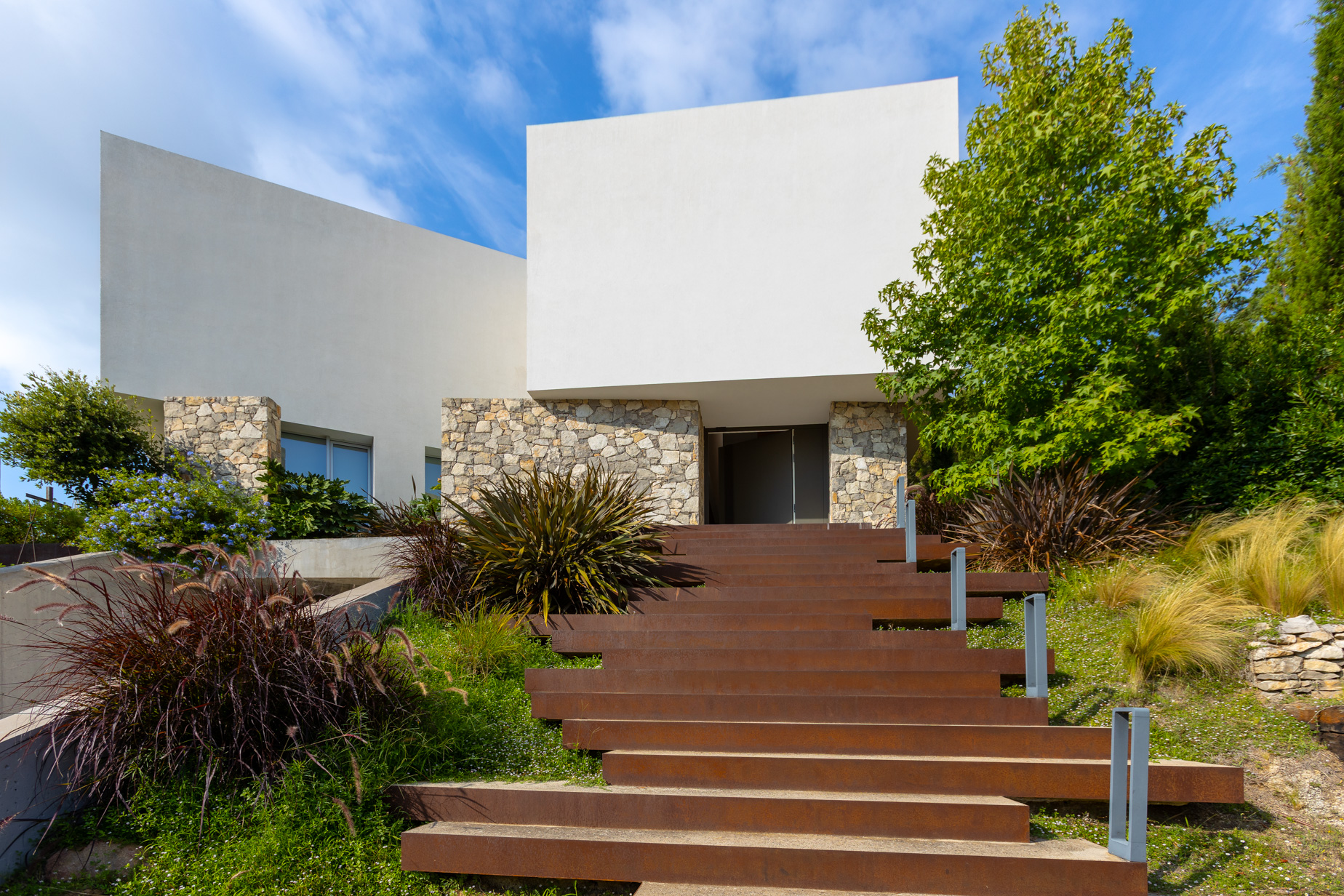 entrada arquitectónica moderna con garaje y piedra natural en villa del Maresme