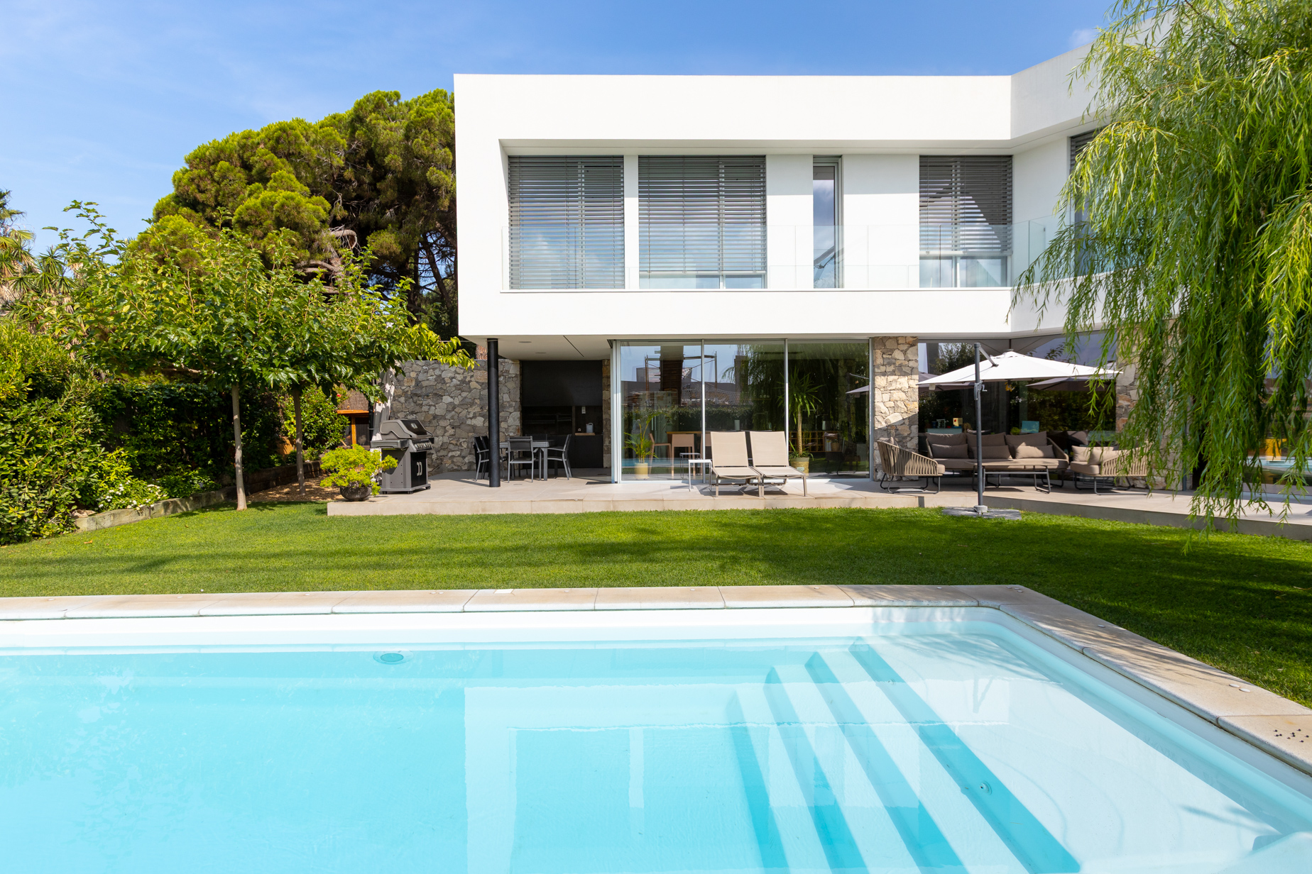 entrada arquitectónica moderna con garaje y piedra natural en villa del Maresme