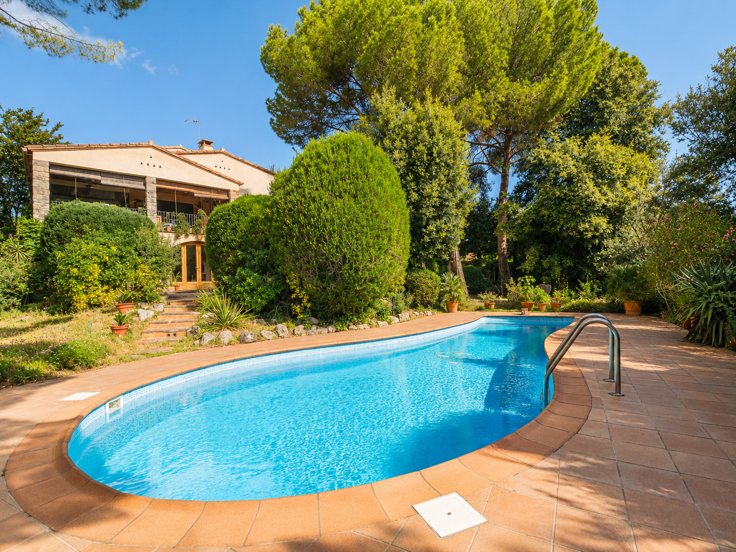 Casa en venta en L'Ametlla del Vallès, entorno residencial consolidado, con gran parcela plana, jardín maduro, piscina privada, porche, salón con chimenea y distribución familiar en tres niveles.