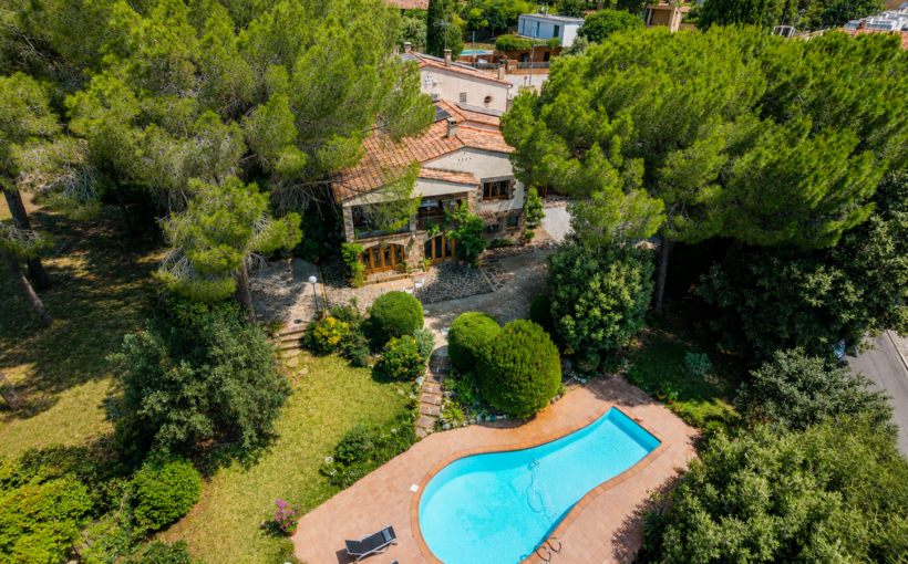 Casa en venta en L'Ametlla del Vallès, entorno residencial consolidado, con gran parcela plana, jardín maduro, piscina privada, porche, salón con chimenea y distribución familiar en tres niveles.