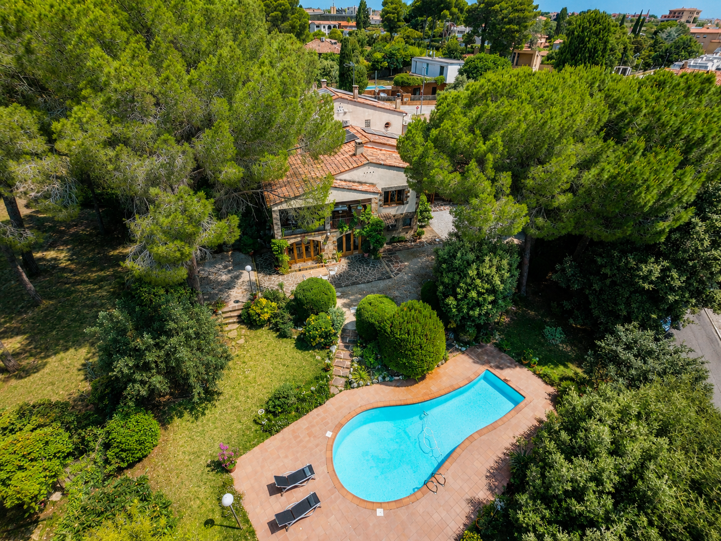 Casa en venta en L'Ametlla del Vallès, entorno residencial consolidado, con gran parcela plana, jardín maduro, piscina privada, porche, salón con chimenea y distribución familiar en tres niveles.