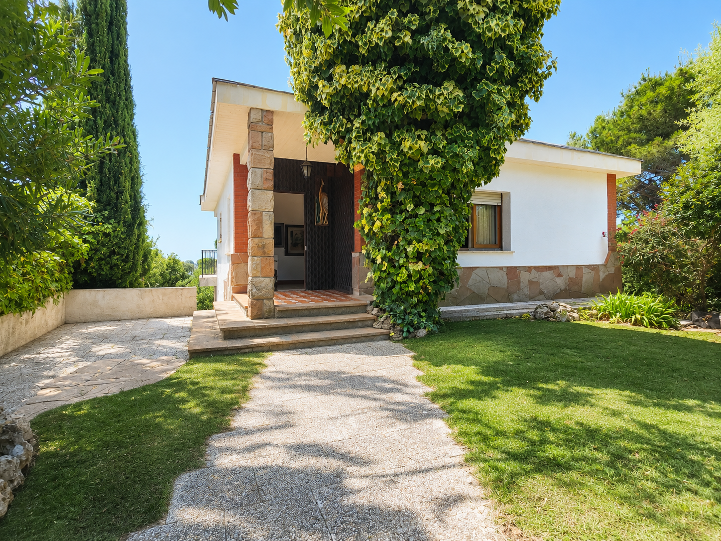 Casa unifamiliar en venta en El Serrat, L’Ametlla del Vallès, con vistas abiertas a mar y montaña, terrazas, jardín boscoso, piscina en desuso y parcela urbana anexa opcional.