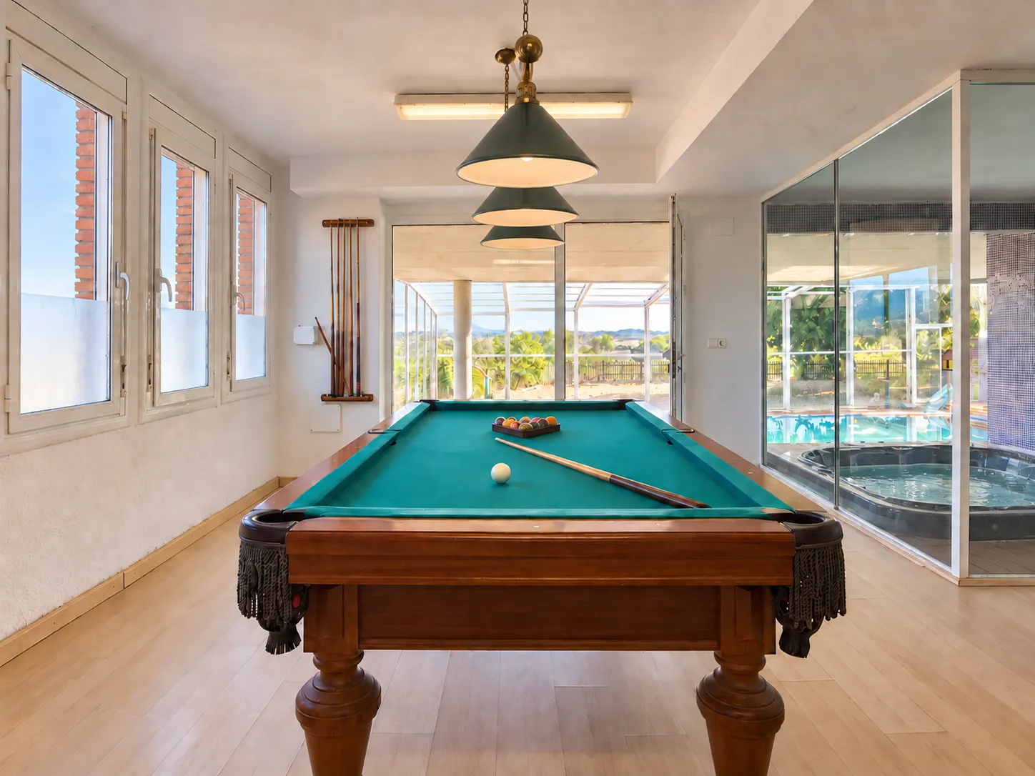 Sala de billar junto al cerramiento acristalado de la piscina