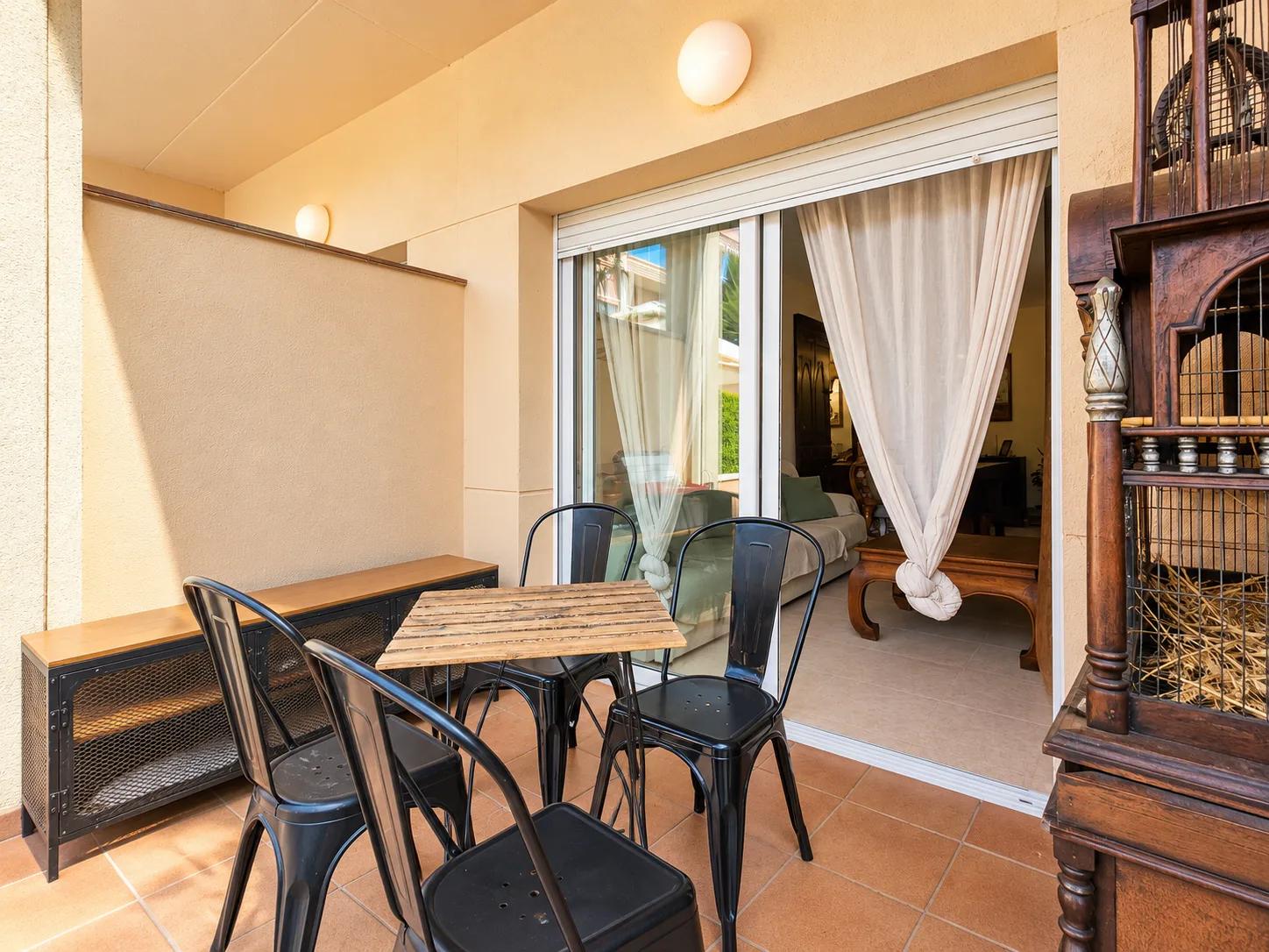Terraza junto al salón con mesa exterior y toldo