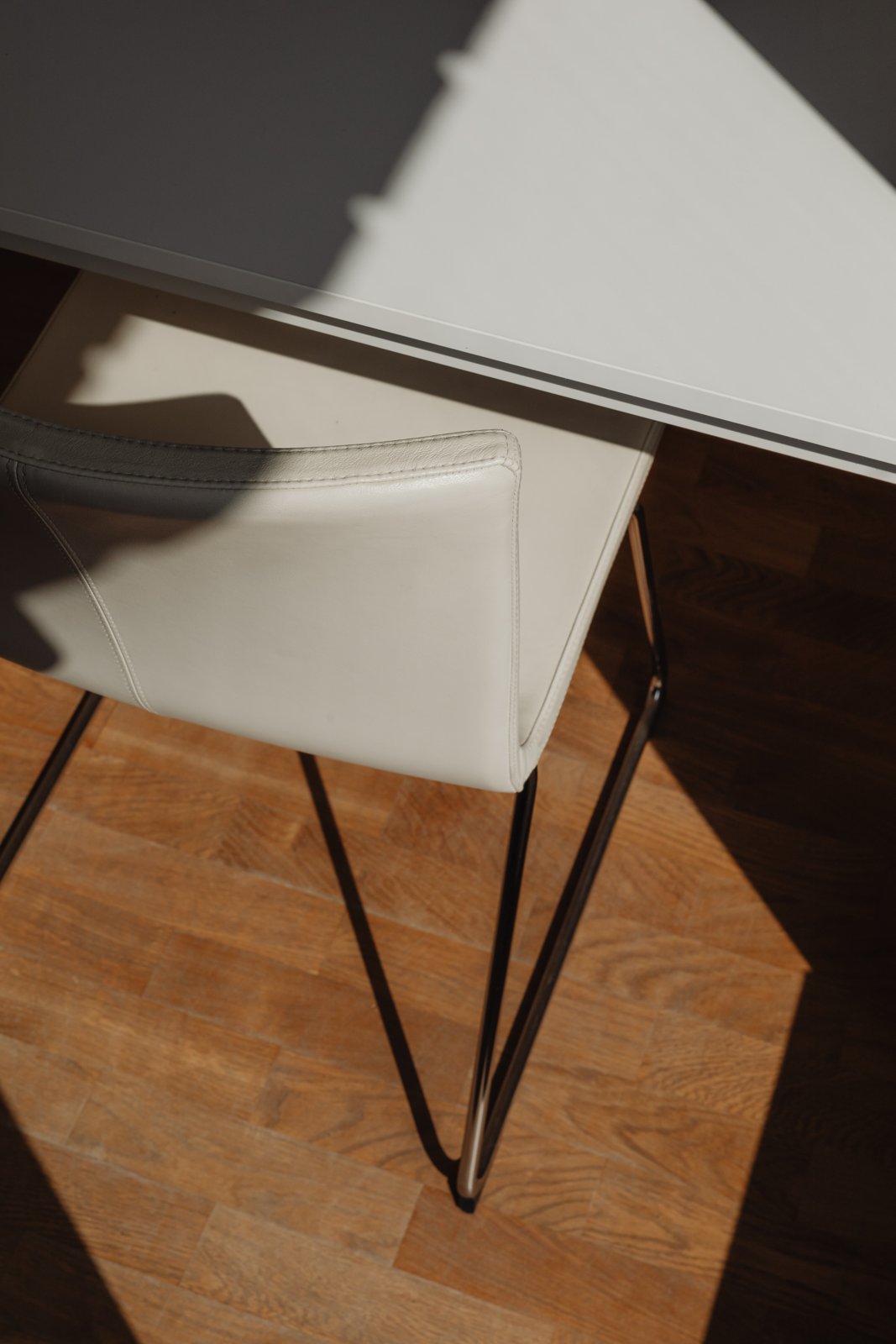 Luz natural sobre una silla de piel clara y suelo de madera