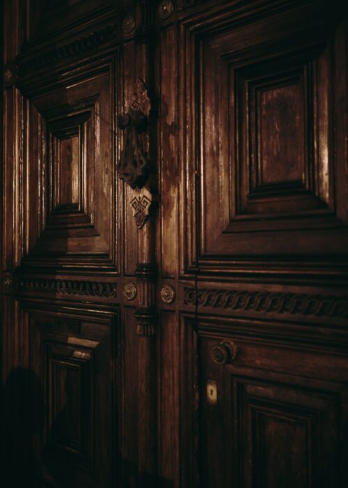 Detalle de una puerta antigua de madera tallada en Barcelona.